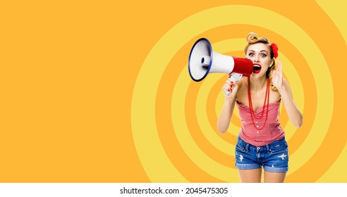 Happy Excited Woman Holding Mega Phone And Shout Advertising Something. Blond Girl In Pin Up Style With Wide Open Mouth, Over Orange Yellow Spiral Background. Female Model Retro Vintage Studio Concept