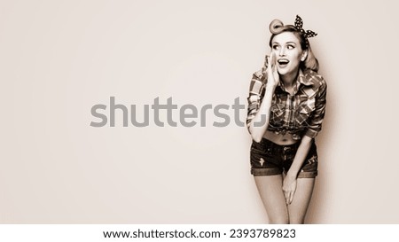 Happy excited woman holds hand near open mouth, looking aside saying something. Girl dressed in pinup style. Pin up model at retro fashion vintage concept. Brown toned monochrome bw photo.