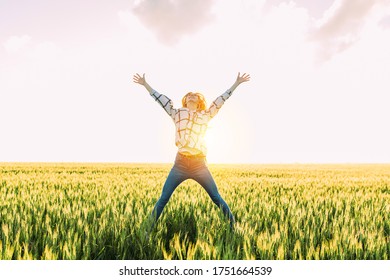 Happy Excited Woman Jumps Up In Golden Wheat, In A Wheat Field