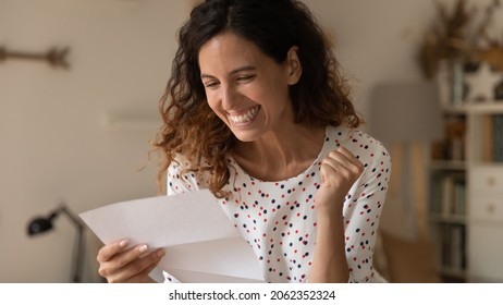 Happy excited woman reading paper letter and getting unbelievable good news, making yes winner hand gesture, celebrating loan or statement approval, job achieve, promotion, success