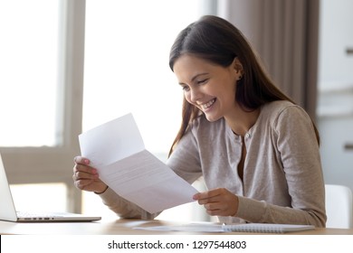 Happy excited woman student customer reading letter with good news, great cheap offer, get job opportunity, scholarship admission, loan approval, money refund holding paper mail bank statement - Shutterstock ID 1297544803