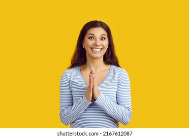 Happy Excited Woman Waiting For Surprise, Holding Hands Together And Smiling. Young Girl Rubbing Palms Against Each Other In Anticipation Of Present And Looking At Something With Funny Face Expression