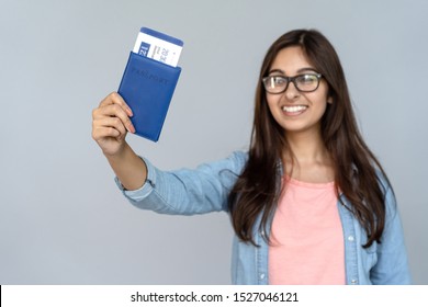 Happy Excited Young Adult Indian Woman Student Holding Passport With Airplane Flight Ticket Boarding Pass Standing Isolated On Grey Background With Copy Space, Travel By Plane, Study Abroad Concept