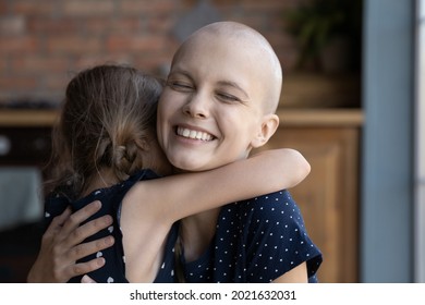 Happy Excited Young Cancer Mom Embracing Daughter Kid. Ill Mother And Child Hugging, Celebrating Therapy Good Result, Feeling Relief. Kid Giving Love And Support To Mom With Oncology Disease