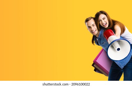 Happy excited young couple with megaphone and shopping bags. Man and woman shout saying advertising something in loudspeaker mega phone. Sales, rebates, discounts offers ad concept. Yellow color back. - Powered by Shutterstock