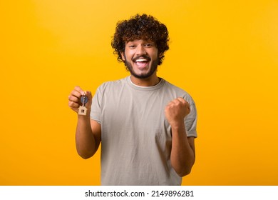 Happy excited young Indian guy holding keys of their new home isolated on yellow background, male student moved away from parents, rent apartment and will live independently - Shutterstock ID 2149896281