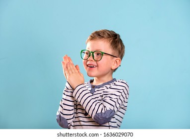 Happy Exciting Child Boy Giving Applaud.  School Kid Clapping Hands Isolated On Blue Background. 