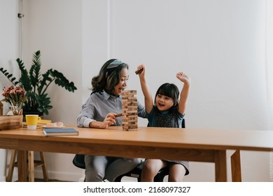 Happy Exciting Moments Of Asian Grandmother With Her Granddaughter Playing Jenga Constructor. Leisure Activities For Children At Home.