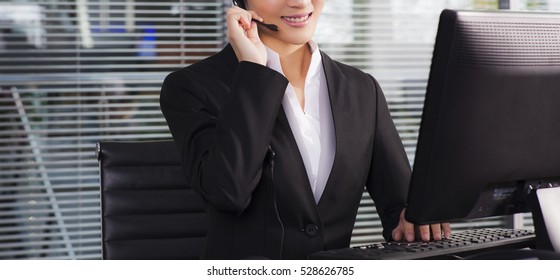 A Happy Executive Wearing Suit Calling Customer Service On The Phone And Sitting On A Desk In The Office