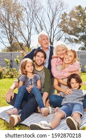 Happy Extended Family With Children And Grandparents Together In The Garden In Summer