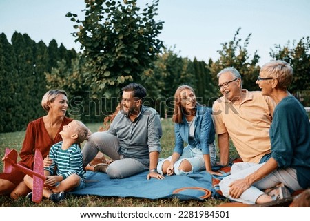 Happy extended family enjoying in conversation while relaxing in their backyard. Copy space.