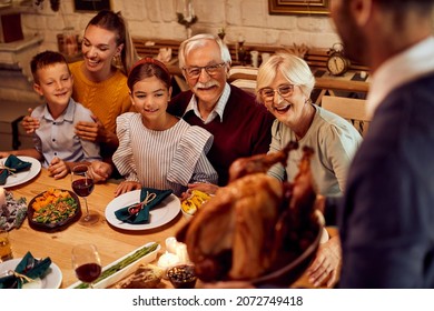 Happy Extended Family Enjoying In Traditional Thanksgiving Meal At Dining Table At Home.