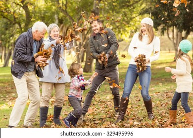 Happy extended family throwing leaves around on an autumns day - Powered by Shutterstock