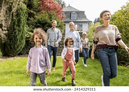 Happy extended family walking in garden of their home