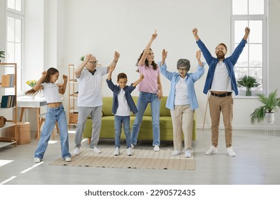 Happy extended multigenerational family all together having fun at home. Funny, overjoyed, excited mother, father, grandmother, grandfather and children dancing in a big, spacious living room interior - Powered by Shutterstock