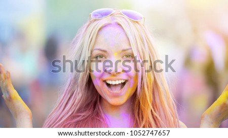 Happy face of girl enjoying Holi festival atmosphere, summer party celebration