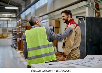 Happy Factory Worker Communicating With Company Manager At Woodworking Industrial Facility. 