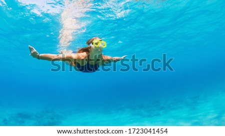Happy family - active young woman in snorkeling mask dive, swim underwater to see tropical fishes in sea lagoon pool. Travel adventure, swimming activity, watersports on summer beach cruise with kid