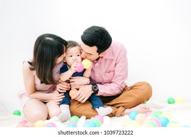 Happy Family - Adorable Asian Chubby Baby Boy Playing A Colorful Plastic Ball With Father And Mother In White Living Room On Vacation , Lifestyle Concept