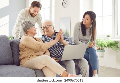 Happy family, aging old parents and adult children, two generations learn using laptop online home. Senior people, grown kids in loving kind affection, trust, family care, peace over generations  - Powered by Shutterstock