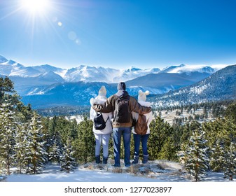 Happy Family With Arms Around Each Other Enjoying Beautiful  Mountain View On Winter  Hiking Trip. Rocky Mountain National Park. Close To Estes Park, Colorado, USA