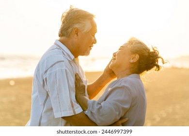 Happy family Asian senior couple having romantic moments dancing together at tropical beach at summer sunset. Elderly husband and wife enjoy outdoor lifestyle travel nature ocean on holiday vacation. - Powered by Shutterstock