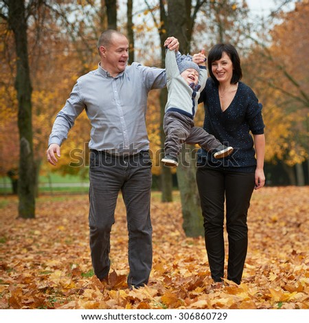 happy family in autumn park on yellow leaves