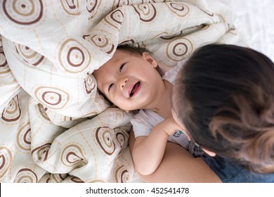 Happy Family. Baby And Mother Play, Kiss, Tickle, Laugh In Bed