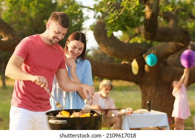 Happy Family At Barbecue Party On Summer Day