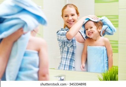 happy family in the bathroom. mother of a child daughter with a towel dry hair