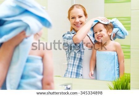 happy family in the bathroom. mother of a child daughter with a towel dry hair