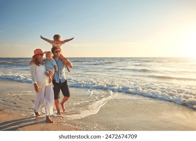 Happy family, beach holiday and walking, smile for vacation on tropical island. Man, woman and children together with sunglasses by ocean for travel with wellness, mockup space at sunset in Mauritius - Powered by Shutterstock