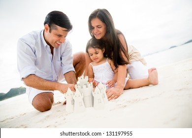 Happy Family At The Beach Making Sand Castles