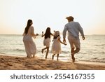 happy family, family, beach, vacation, summer, happy, relaxation, fun, together, kids. A family of four is running on the beach. Scene is joyful and carefree, as family members are having fun together