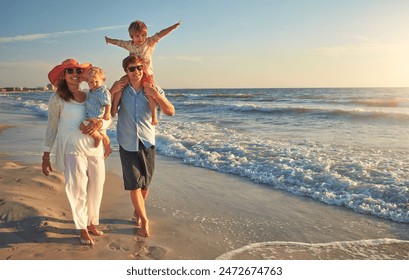 Happy family, beach vacation and walking, smile for holiday on tropical island. Man, woman and children together with sunglasses by ocean for travel with wellness, mockup space at sunset in Mauritius - Powered by Shutterstock