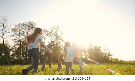 Happy Family. Big Family Running With A Kite. People In The Park Children Child Running Together In The Park At Sunset Silhouette. Mom Dad Daughter And Son Are Running. Concept Dream. Kids Fun Run