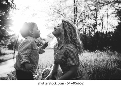 Happy Family - Black And White Photo. Mother Playing With Son Sgainst The Sun In Summer Day. Love, Sentiment And Happy Family Concept.