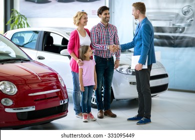 Happy  Family Buy  New Car, Car Dealer Handshaking With Daddy Congratulated The Family On A New Car