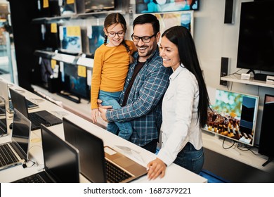 Happy Family Buying Laptop In Store.