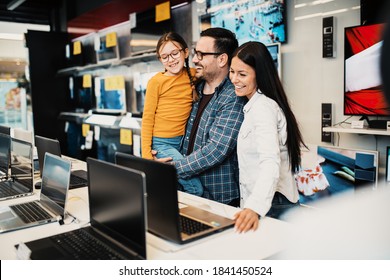 Happy Family Buying Laptop In Store.