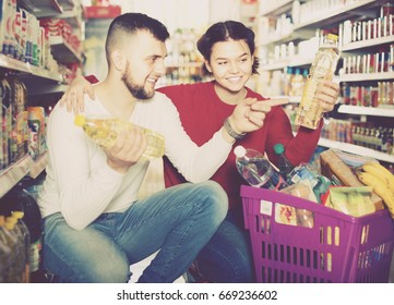 Happy Family Buying Vegetable Oil At Grocery Shop
 