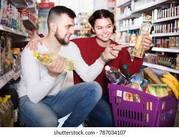 Happy Family Buying Vegetable Oil At Grocery Shop
 