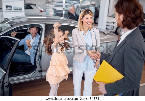 Happy\
family in car saling salon buying new\
automobile\
