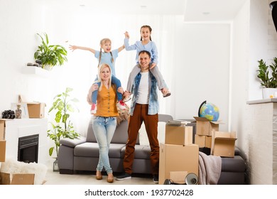 Happy family with cardboard boxes in new house at moving day.
