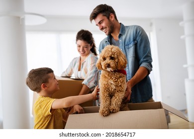 Happy Family With Cardboard Boxes In New House At Moving Day.