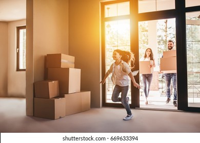 Happy family with cardboard boxes in new house at moving day. - Shutterstock ID 669633394