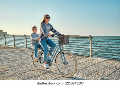 Happy family, Carefree mother and son with bike riding on beach having fun, on the seaside promenade on a summer day, enjoying vacation. Togetherness Friendly concept - Powered by Shutterstock