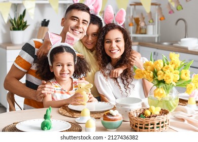 Happy family celebrating Easter at dining table in kitchen - Shutterstock ID 2127436382