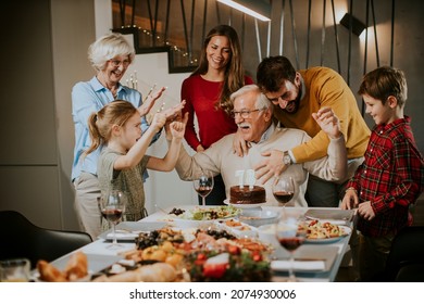 Happy family celebrating grandfather birthday with cake and candles at home - Powered by Shutterstock