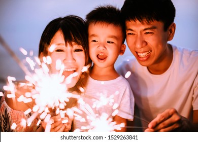 Happy Family Celebrating New Year With Sparklers 